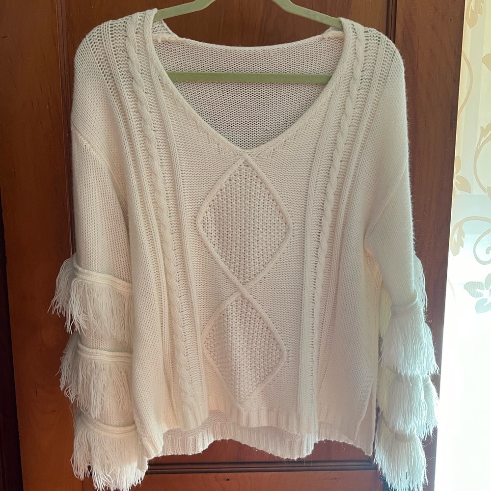 White knit sweater with sleeve ruffles